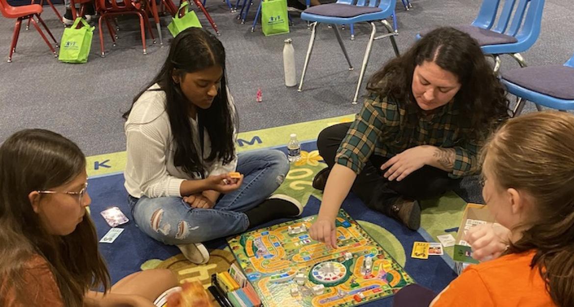 Teens playing The Game of LIfe on the floor